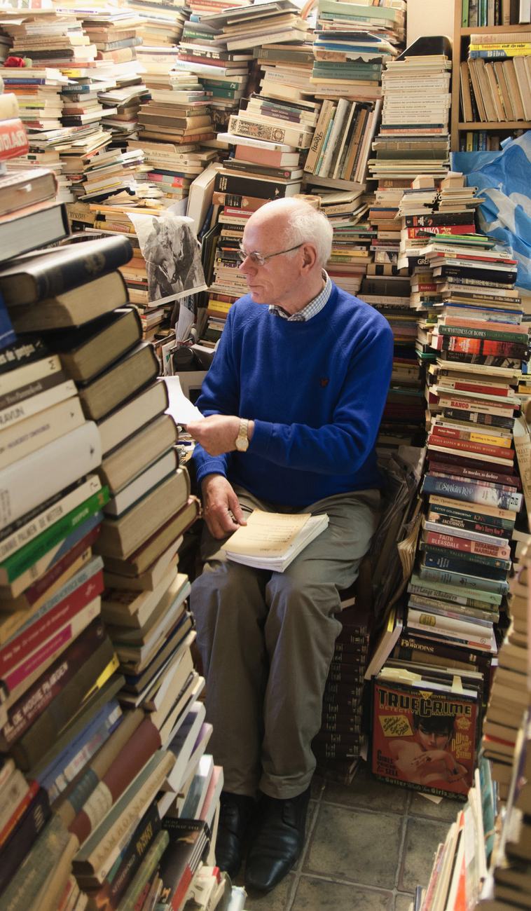 Bookseller among towering stacks